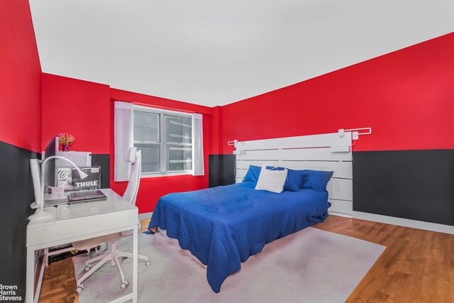 bedroom featuring wood finished floors and baseboards