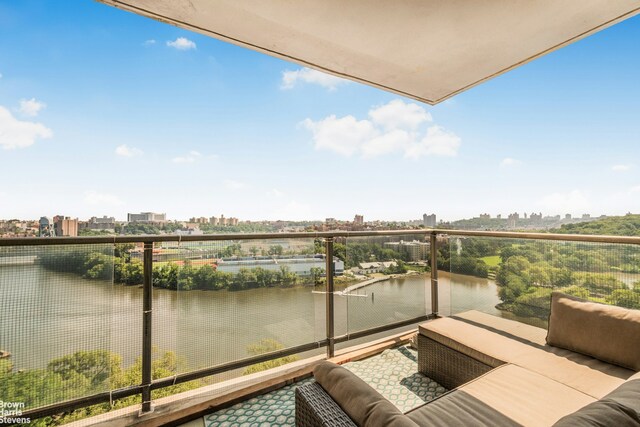 balcony with a view of city, a water view, and an outdoor living space