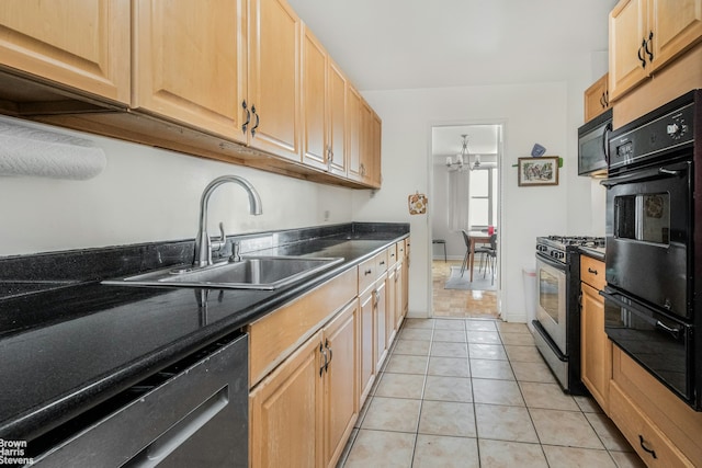 kitchen with dark countertops, an inviting chandelier, a sink, light tile patterned floors, and black appliances