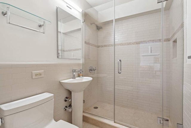 bathroom with tile walls, an enclosed shower, and toilet