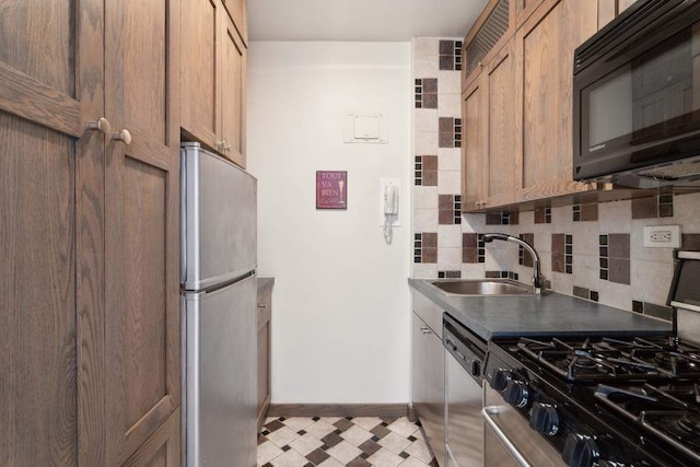 kitchen featuring sink, decorative backsplash, and stainless steel appliances