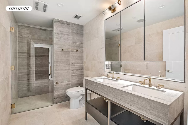 bathroom with tile walls, an enclosed shower, vanity, tile patterned floors, and toilet