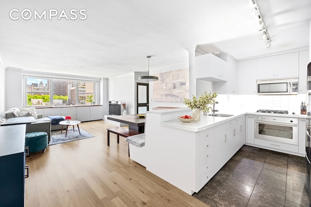 kitchen with stainless steel appliances, open floor plan, light countertops, and backsplash