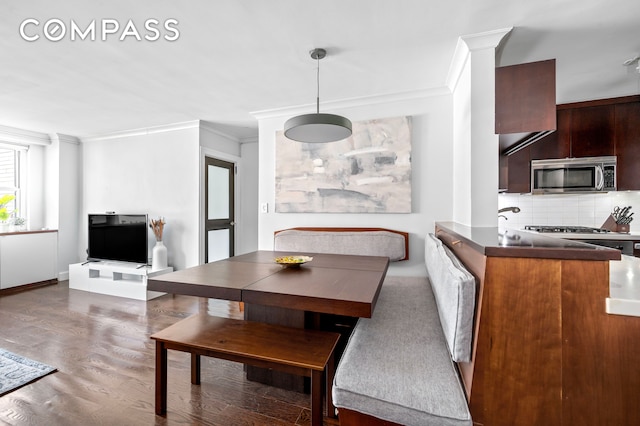 dining space with ornamental molding and wood finished floors