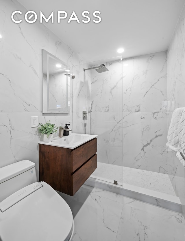 bathroom with toilet, a marble finish shower, vanity, marble finish flooring, and tile walls