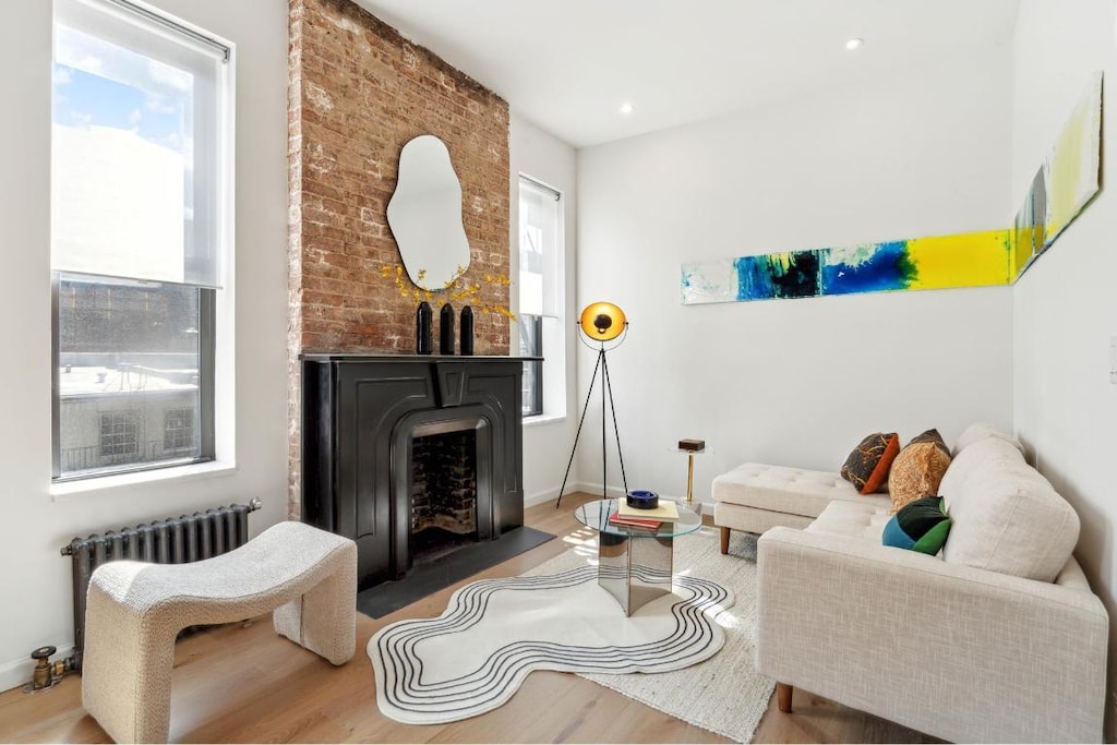 living room featuring plenty of natural light, wood-type flooring, and radiator