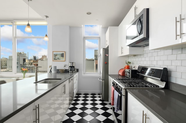 kitchen with appliances with stainless steel finishes, sink, and white cabinets