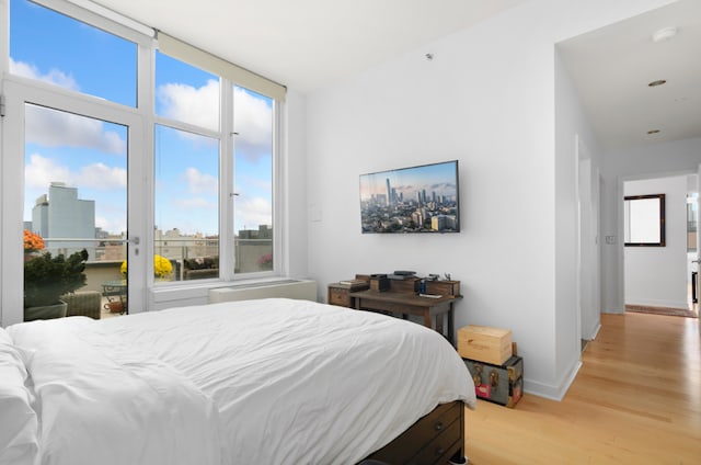 bedroom with access to exterior and light wood-type flooring