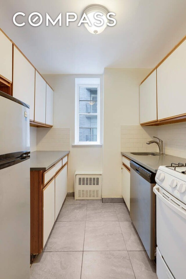 kitchen featuring tasteful backsplash, white cabinets, and white appliances