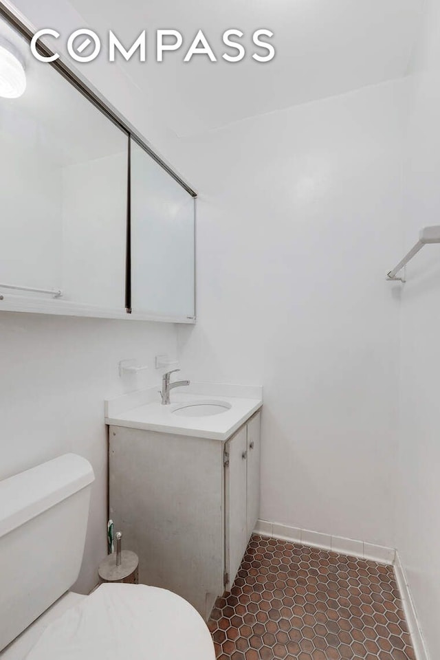 bathroom featuring vanity, toilet, and baseboards