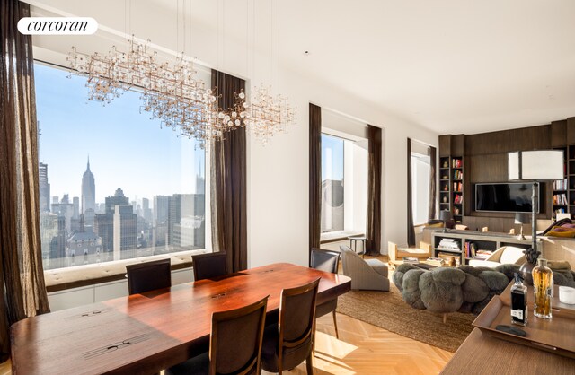 dining space with a notable chandelier, a wealth of natural light, and light parquet floors