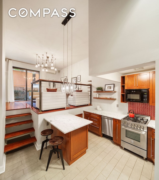 kitchen featuring light stone counters, a breakfast bar, open shelves, appliances with stainless steel finishes, and brown cabinets