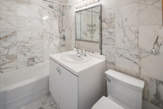 full bathroom featuring tiled shower / bath combo, vanity, and toilet