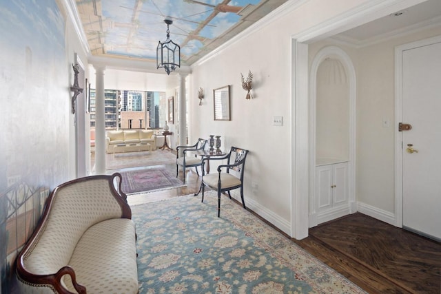 sitting room with decorative columns, ornamental molding, and dark parquet floors