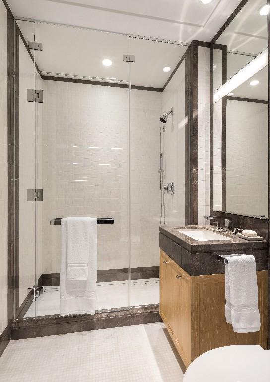 bathroom with tile patterned floors, vanity, and a shower with door