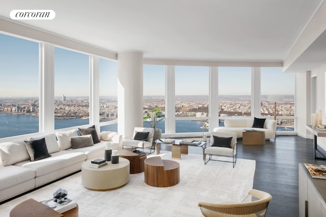 living area with floor to ceiling windows, wood finished floors, visible vents, and a water view