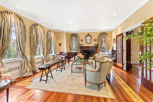 living room featuring hardwood / wood-style floors, crown molding, radiator, and french doors