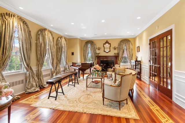 living area featuring hardwood / wood-style floors, radiator heating unit, ornamental molding, and french doors