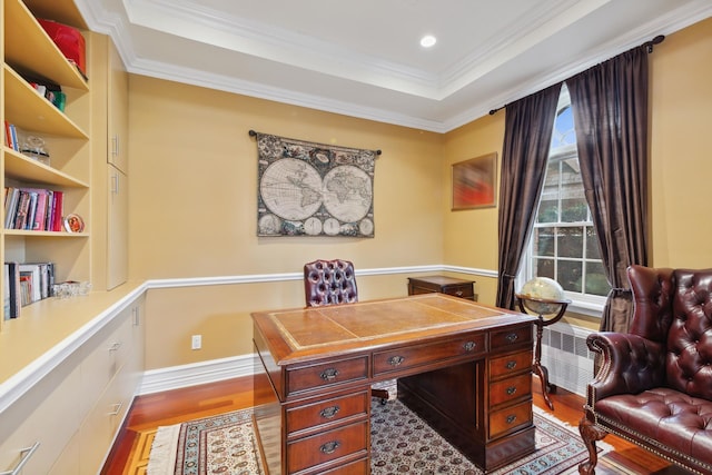 office area with radiator, crown molding, a raised ceiling, and wood finished floors