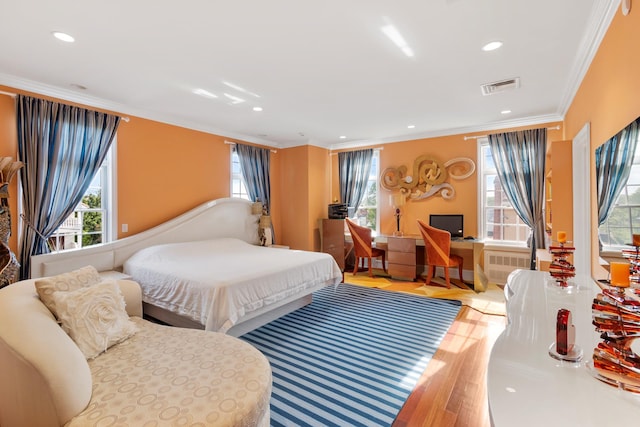 bedroom featuring recessed lighting, wood finished floors, visible vents, radiator heating unit, and crown molding