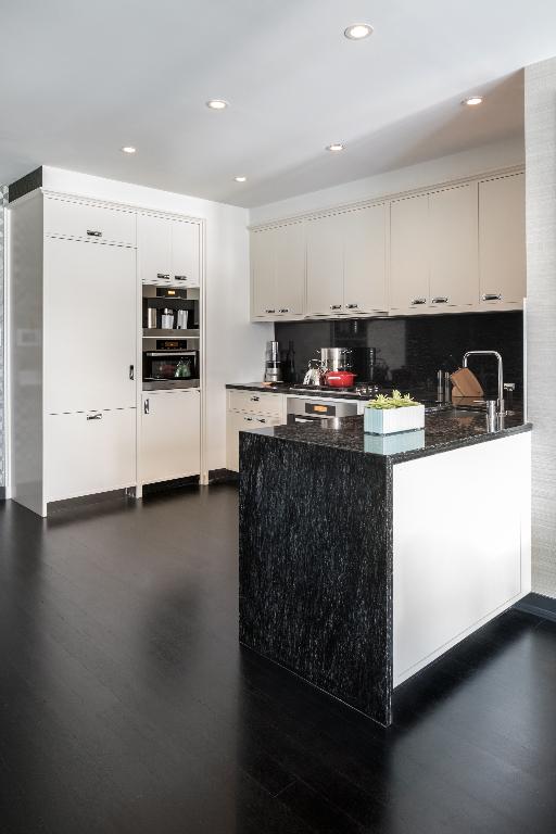 kitchen with white cabinetry, backsplash, sink, and stainless steel oven