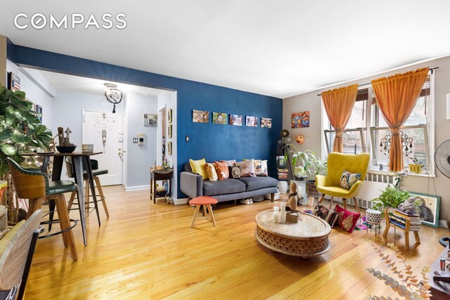 living room with radiator, wood finished floors, and baseboards