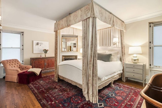 bedroom with crown molding and dark wood-type flooring