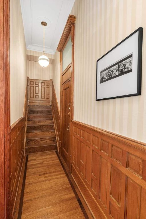 hallway with hardwood / wood-style floors and crown molding