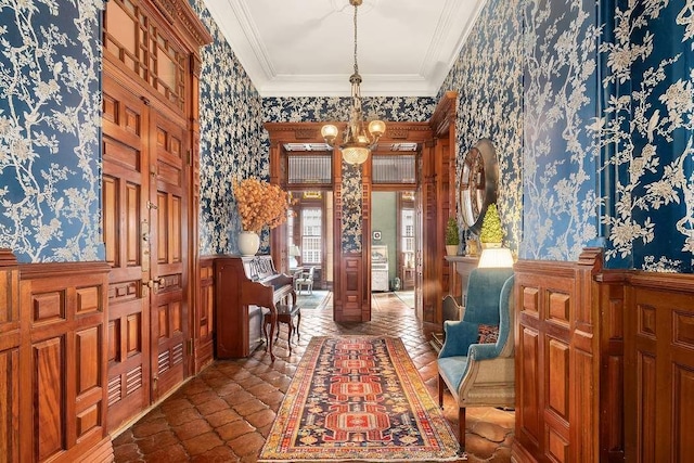 foyer entrance featuring ornamental molding and a chandelier