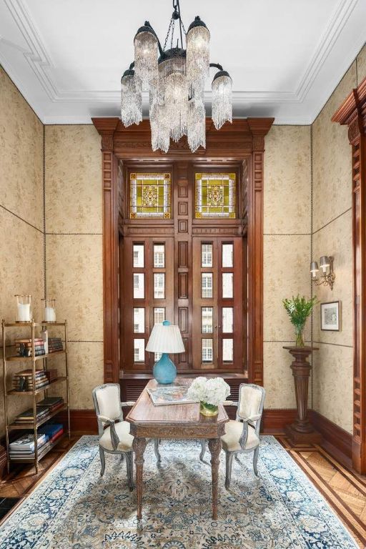 sitting room with crown molding and a notable chandelier