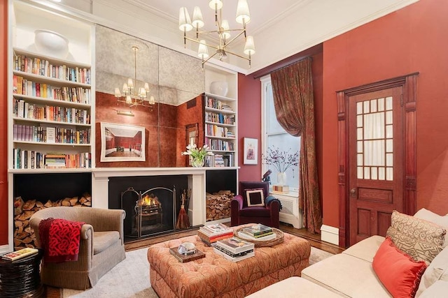 living area featuring crown molding, hardwood / wood-style flooring, built in features, and a notable chandelier