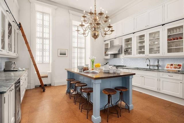 kitchen with sink, a breakfast bar area, white cabinets, a center island, and a barn door