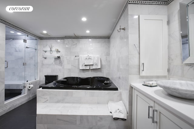 bathroom with vanity, separate shower and tub, tile patterned flooring, and tile walls