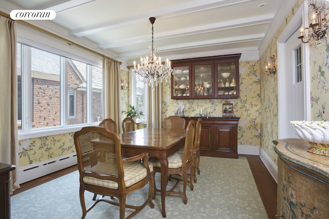 dining room with dark wood-type flooring, a notable chandelier, beam ceiling, and a baseboard heating unit