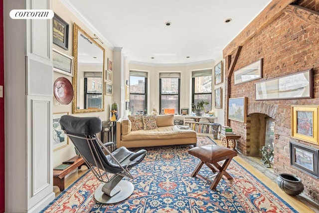 sitting room featuring wood-type flooring, brick wall, and crown molding