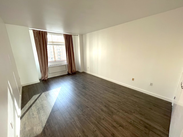 unfurnished room featuring dark wood-type flooring