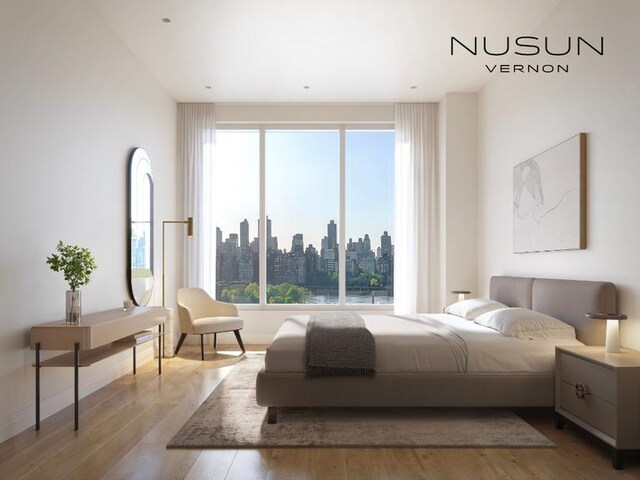 30-55 Vernon Blvd Unit 2G, New York City, NY 11102 - bedroom with wood finished floors, multiple windows, and a skyline view