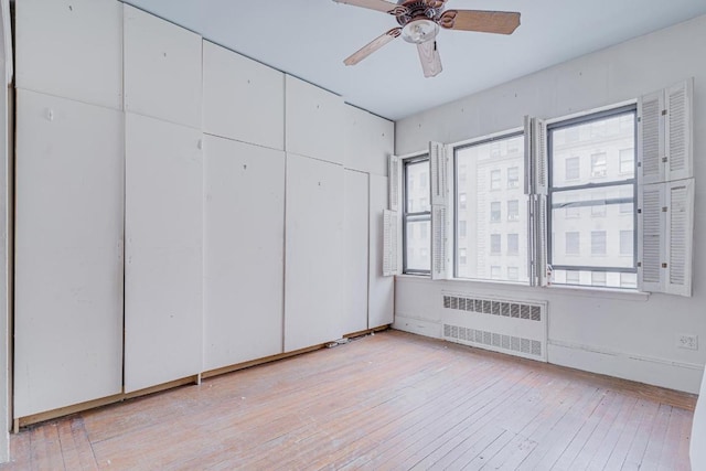 interior space featuring radiator heating unit and light wood-type flooring