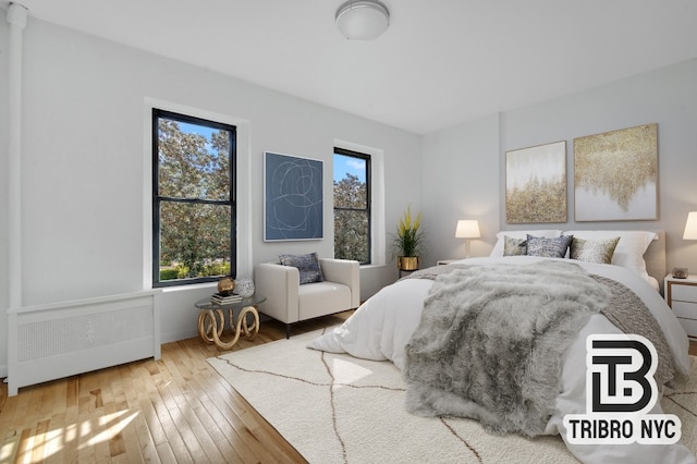 bedroom with wood-type flooring and radiator heating unit