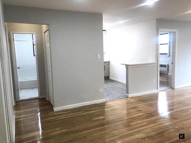 unfurnished room featuring radiator and dark wood-type flooring