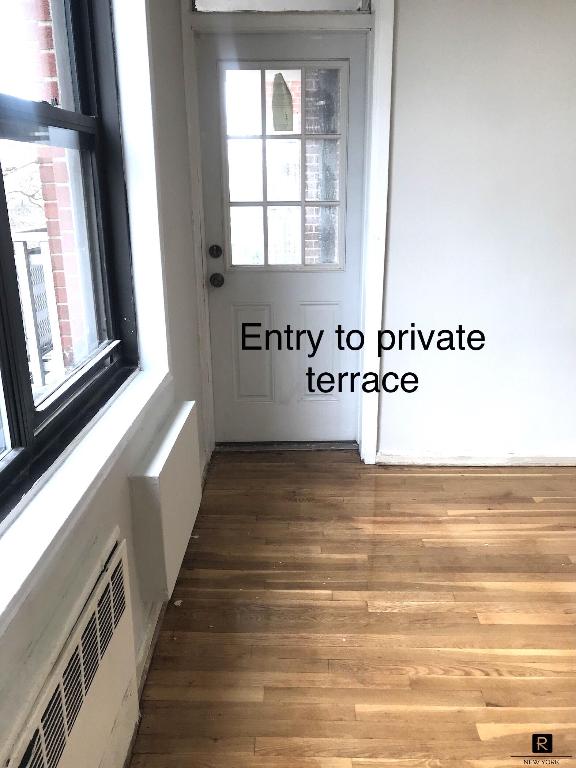 interior space with radiator and hardwood / wood-style flooring