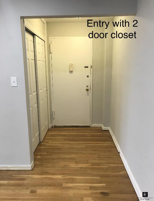 corridor with hardwood / wood-style flooring