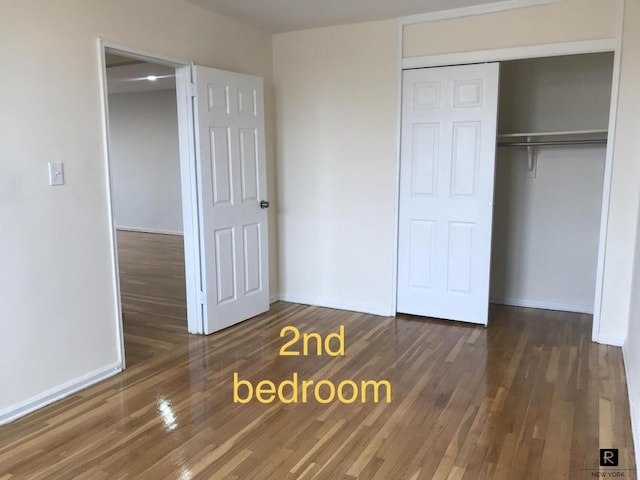 unfurnished bedroom with a closet and dark hardwood / wood-style floors