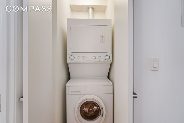 laundry room with stacked washer and dryer and laundry area