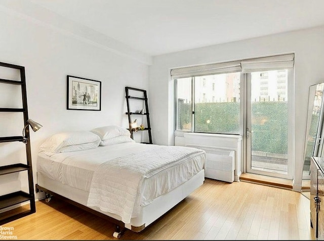 bedroom featuring radiator heating unit and light hardwood / wood-style flooring