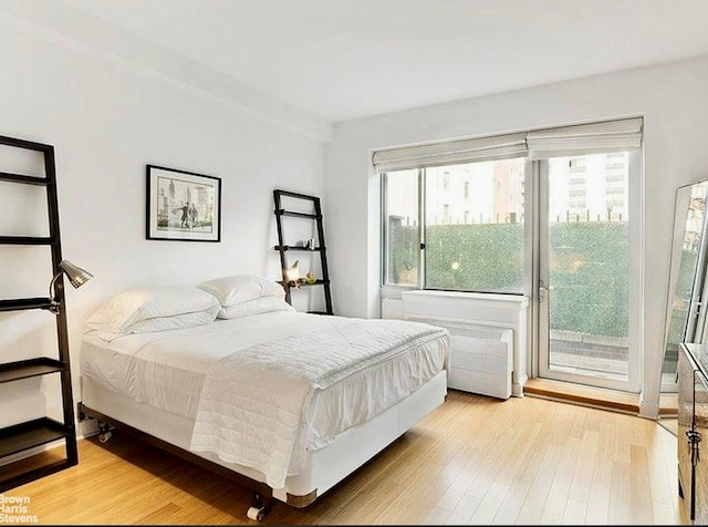 bedroom featuring access to exterior and light wood-style floors