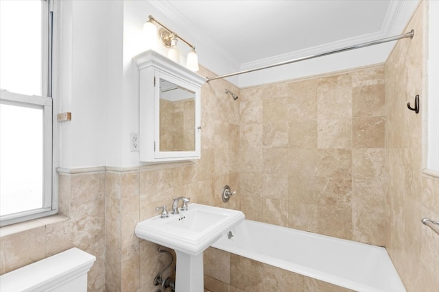 full bathroom featuring toilet, tile walls, tiled shower / bath combo, sink, and crown molding