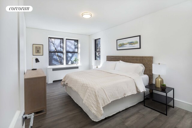 bedroom with dark wood-type flooring and radiator heating unit