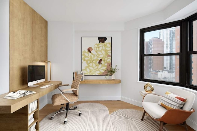 home office with light hardwood / wood-style flooring