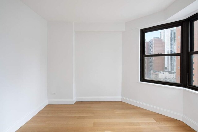 empty room featuring light parquet flooring and radiator heating unit